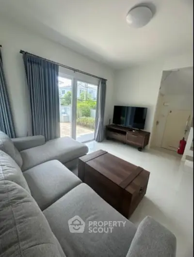 Modern living room with large window and cozy gray sofa
