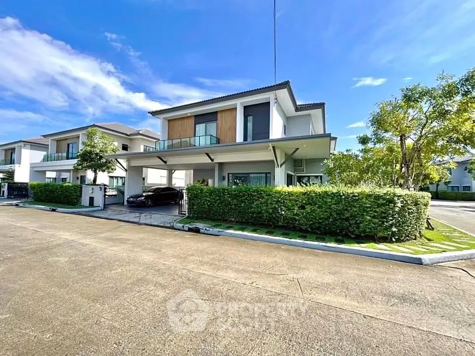 Modern two-story house with lush greenery and spacious driveway