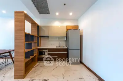 Modern kitchen with sleek design and marble flooring in open layout apartment.
