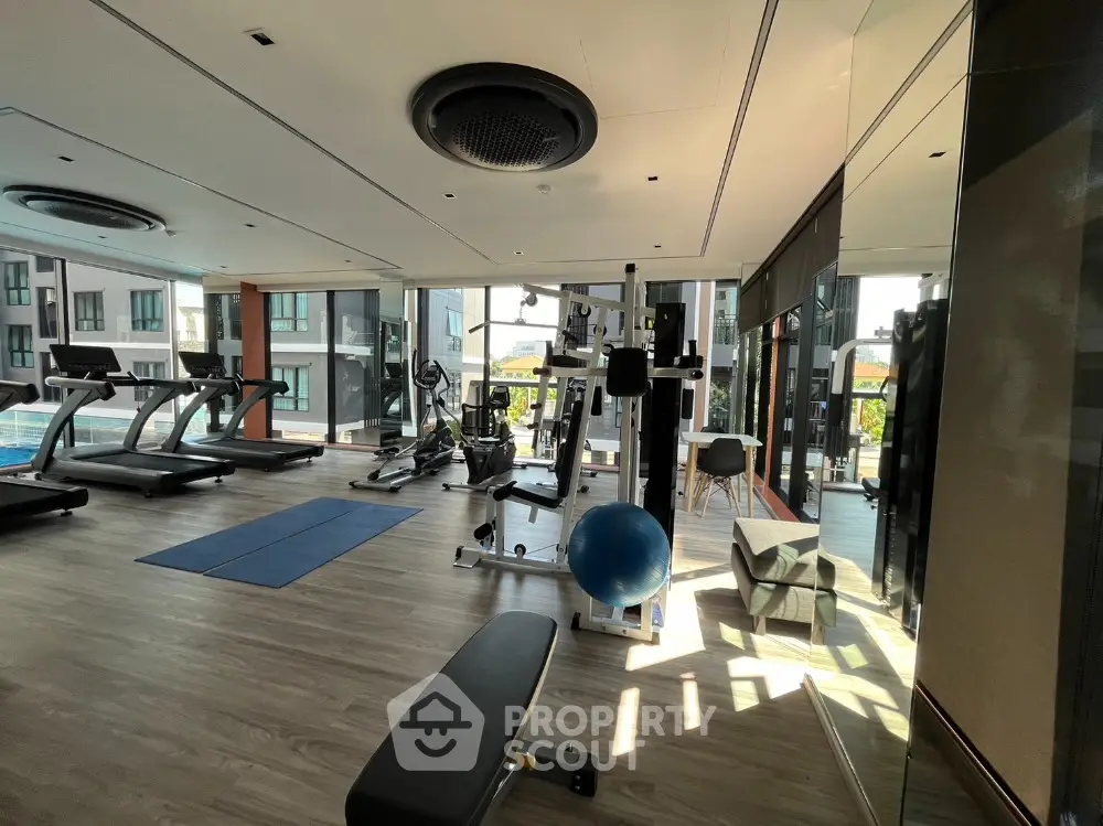 Modern gym with state-of-the-art equipment and large windows offering natural light