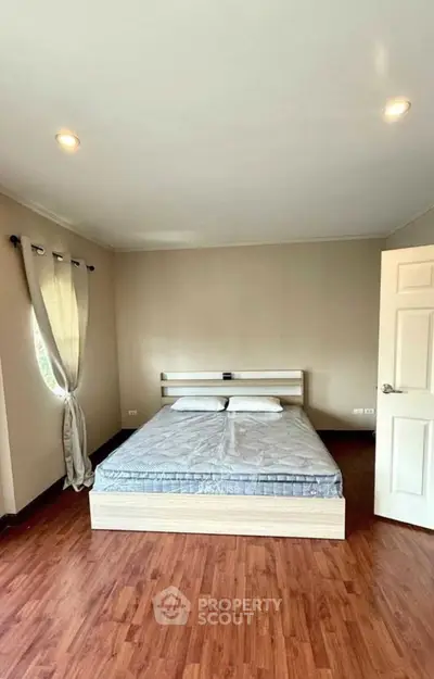 Spacious bedroom with modern design and wooden flooring, perfect for comfort and relaxation.