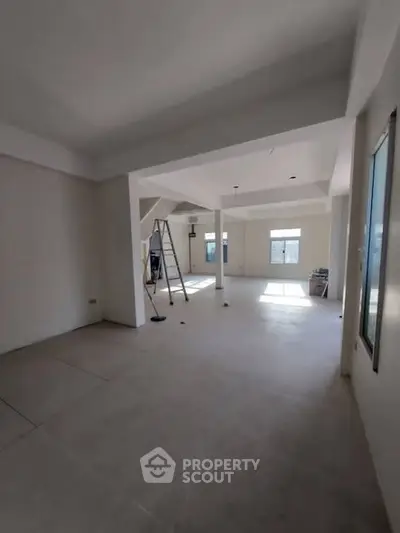 Spacious open-plan interior with large windows and natural light, ideal for modern living.