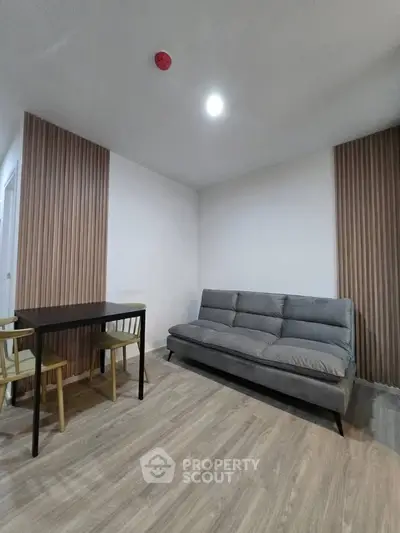 Modern living room with stylish sofa and dining area in contemporary apartment.