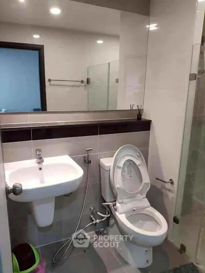 Modern bathroom with sleek fixtures and glass shower enclosure, ideal for contemporary living.