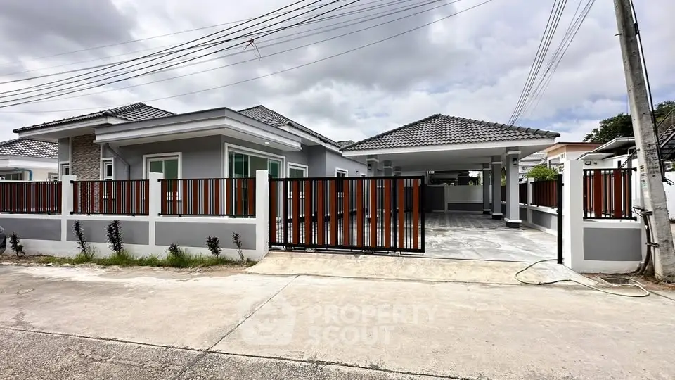 Modern single-story house with gated driveway and tiled roof, perfect for family living.