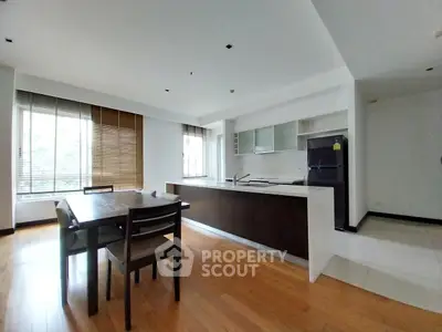 Spacious open-layout kitchen with modern appliances and ample natural light, adjacent to a cozy dining area with a view.