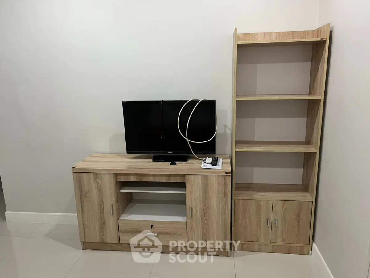 Modern living room with sleek TV stand and wooden bookshelf, perfect for stylish home organization.