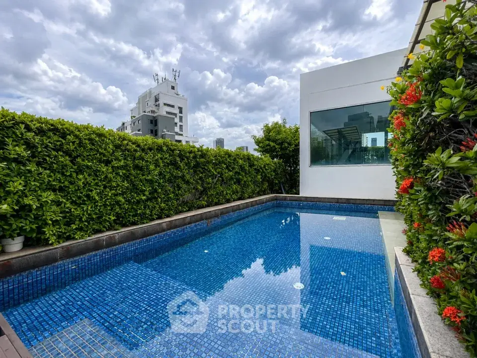 Luxurious rooftop pool with city view and lush greenery, perfect for relaxation and entertainment.