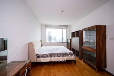 Spacious modern bedroom with city view and elegant wooden furniture