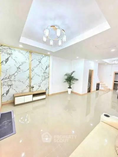 Spacious modern living room with elegant marble accents and stylish lighting.