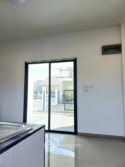Bright interior with sliding glass door leading to outdoor area, showcasing modern design and natural light.