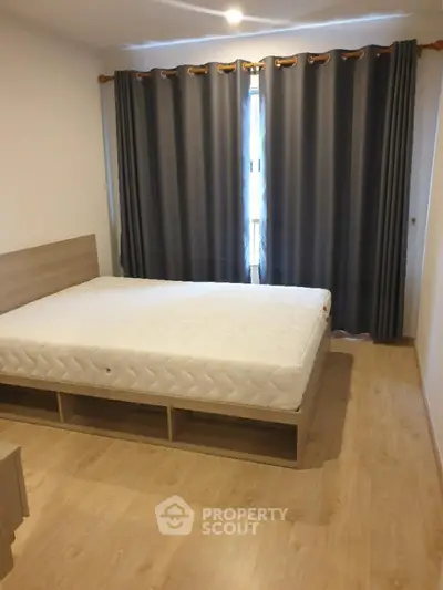 Cozy bedroom with wooden flooring and large bed, perfect for restful nights.