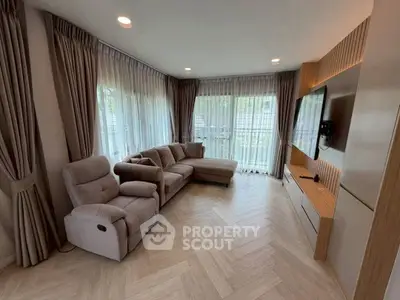 Spacious modern living room with elegant decor and large windows offering natural light.