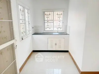 Bright and airy kitchen with closed layout and floral window grills