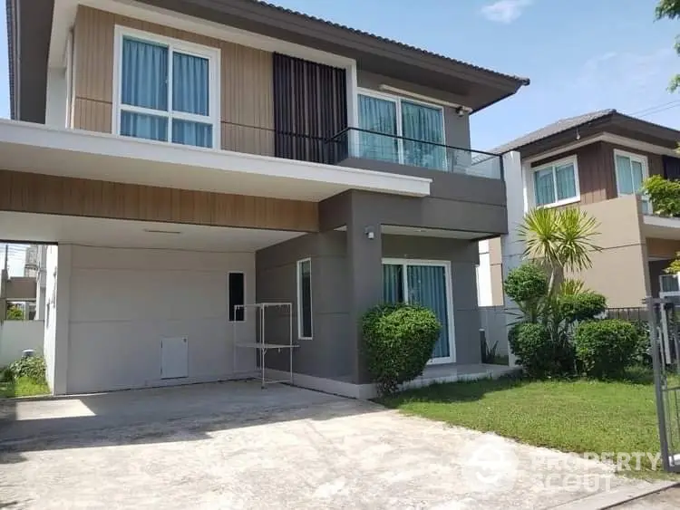 Modern two-story house with spacious driveway and lush green lawn in a serene neighborhood.