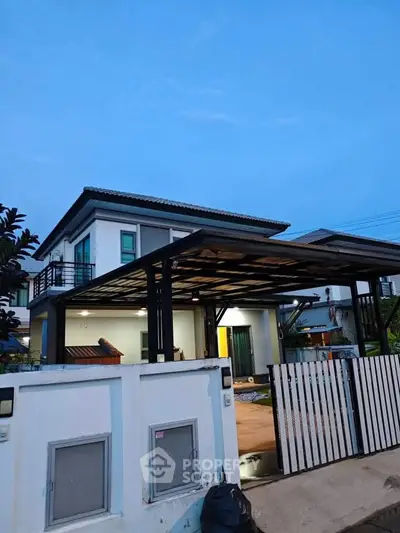 Modern two-story house with sleek design and spacious carport at dusk.