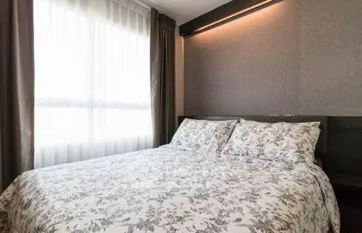 Cozy bedroom with floral bedding and large window for natural light.