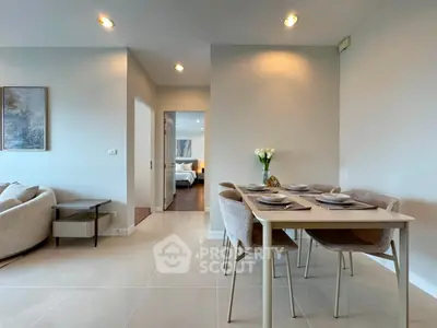 Modern dining area with elegant table setting and view into cozy bedroom