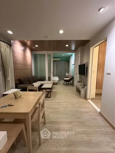 Modern open-plan living room with wooden flooring and stylish furniture in a cozy apartment.
