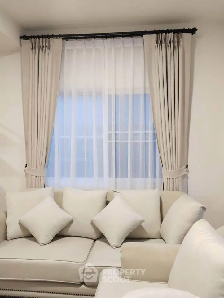 Elegant living room with plush white sofa and stylish curtains, perfect for modern home decor.