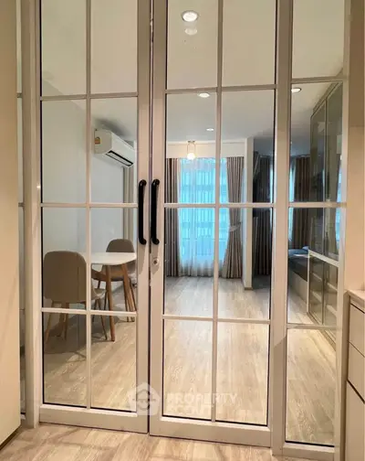 Modern living room with glass doors and elegant dining area.