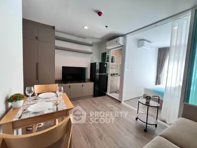 Modern open-plan living room with dining area and kitchen in a stylish apartment.