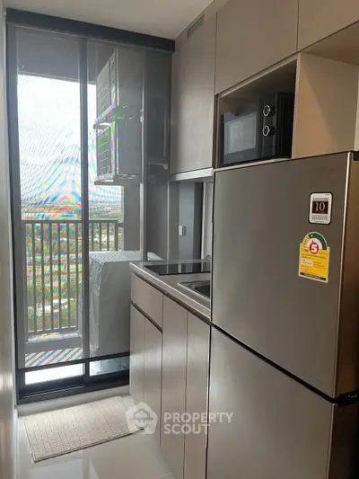 Modern kitchen with sleek appliances and balcony view, perfect for urban living.