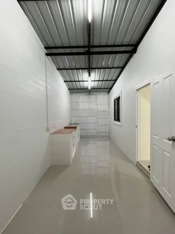 Modern minimalist kitchen with sleek tile flooring and metal ceiling