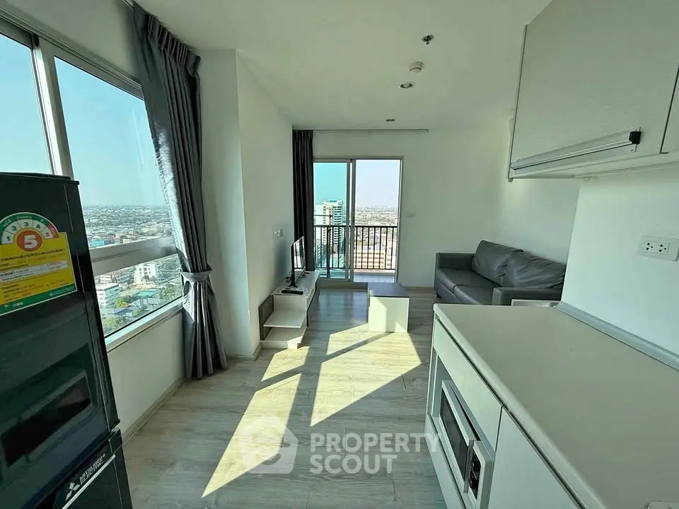 Modern living room with large windows and balcony offering stunning city views.