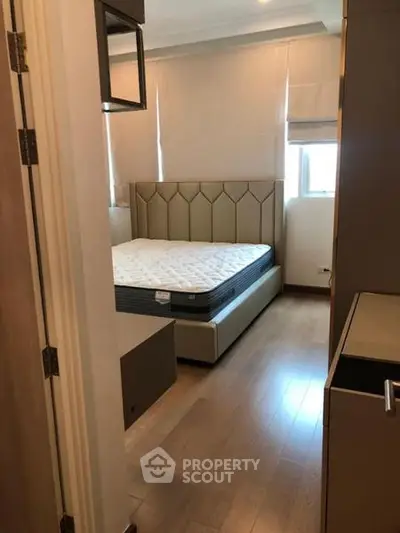 Cozy bedroom with elegant bed and wooden flooring, perfect for restful nights.