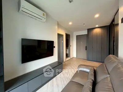 Modern living room with sleek design, featuring a wall-mounted TV and comfortable seating.