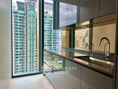 Modern kitchen with sleek cabinets and stunning city view from high-rise window.