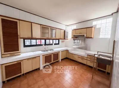 Spacious kitchen with ample cabinetry and tiled flooring, featuring a classic closed layout design.