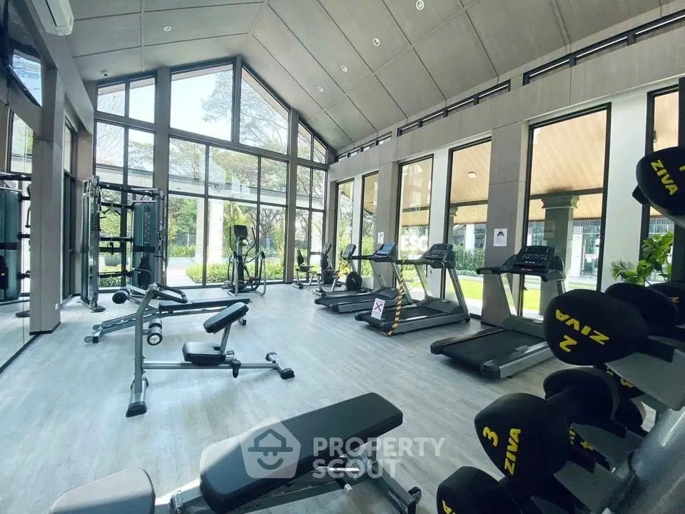 Modern gym with state-of-the-art equipment and large windows offering a scenic view.