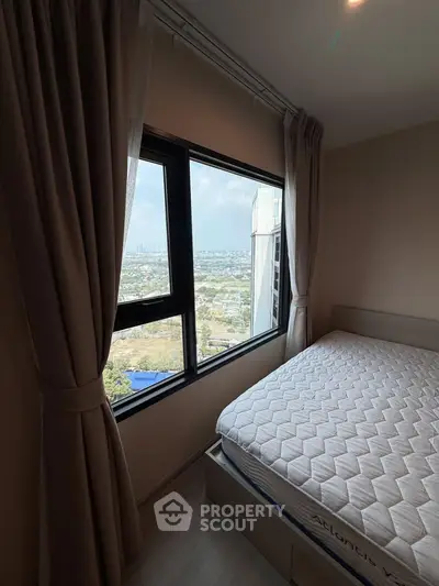 Cozy bedroom with stunning city view from large window, featuring a comfortable bed and elegant curtains.