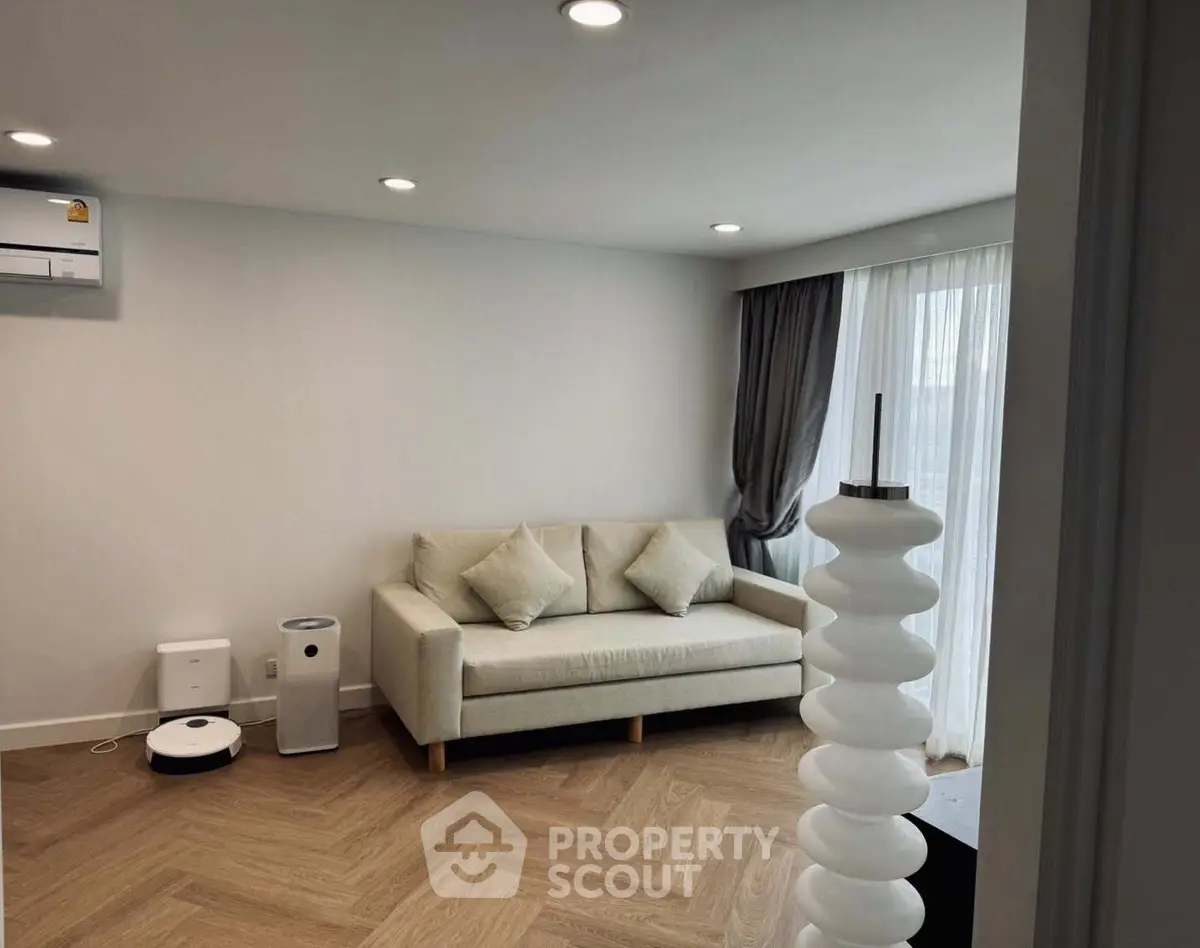 Modern living room with stylish sofa and elegant decor, featuring natural light and contemporary design.