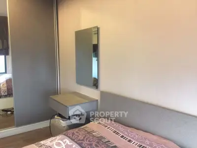 Cozy bedroom with modern decor and mirrored wardrobe in stylish apartment.