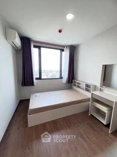 Modern bedroom with city view, featuring sleek furniture and large window for natural light.