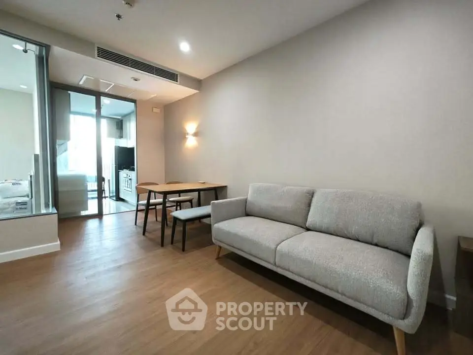 Modern living room with stylish sofa and dining area in open layout apartment.