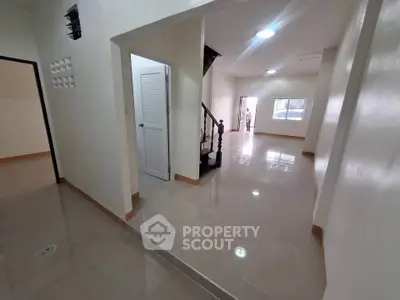 Spacious interior with glossy tiled floors and staircase in modern home