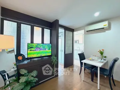 Modern living room with dining area and kitchen, featuring stylish decor and natural light.