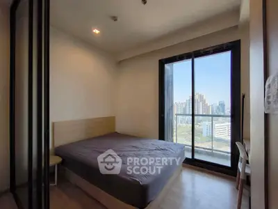 Modern bedroom with large window offering stunning city view, featuring a comfortable bed and sleek design.