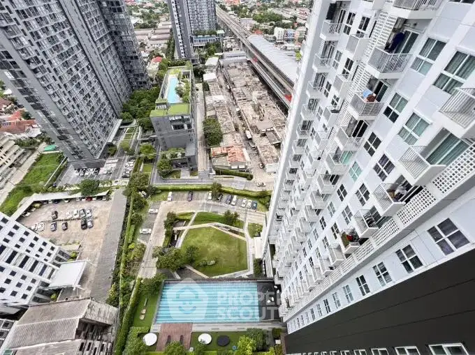Stunning aerial view of modern high-rise buildings with pool and garden in urban setting.