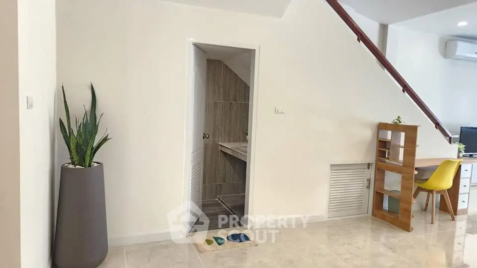 Modern interior with staircase, sleek flooring, and stylish decor in a bright living space.