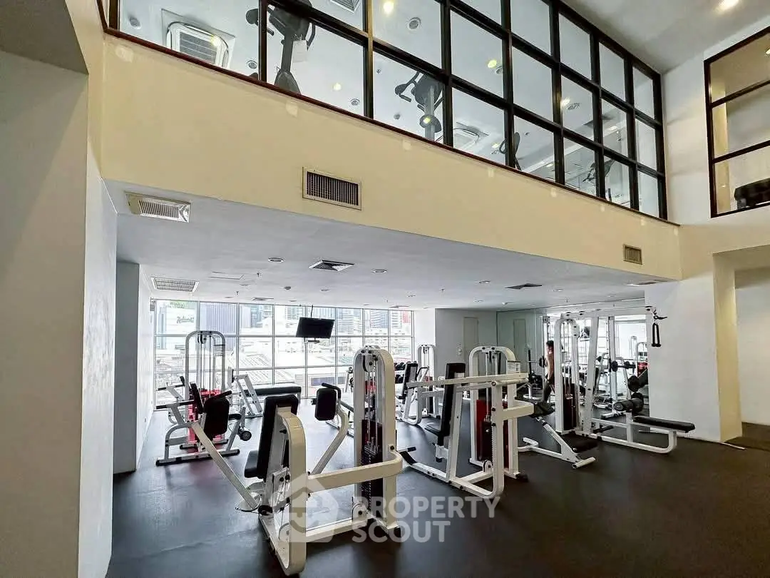Modern gym with state-of-the-art fitness equipment and large windows for natural light.