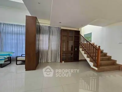 Spacious modern living area with elegant staircase and natural light