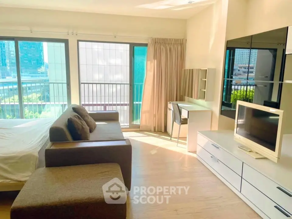 Spacious modern living room with large windows and stylish furniture in a high-rise apartment.