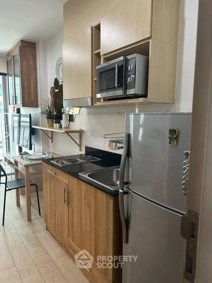 Modern kitchen with wooden cabinets, stainless steel appliances, and a cozy dining area.