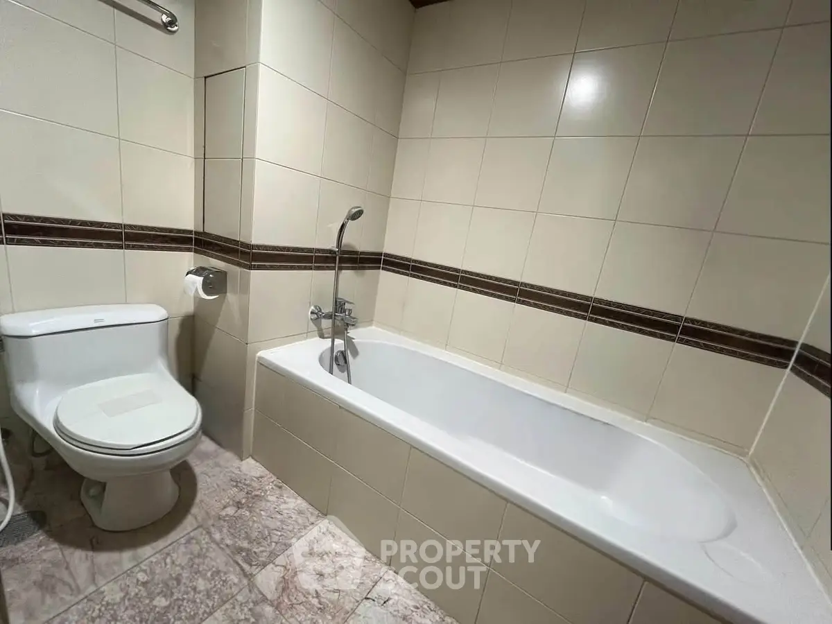 Modern bathroom with sleek bathtub and tiled walls, perfect for relaxation and comfort.