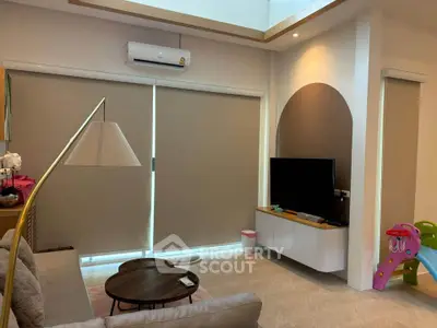 Modern living room with sleek furniture and large windows, featuring a cozy ambiance and stylish decor.